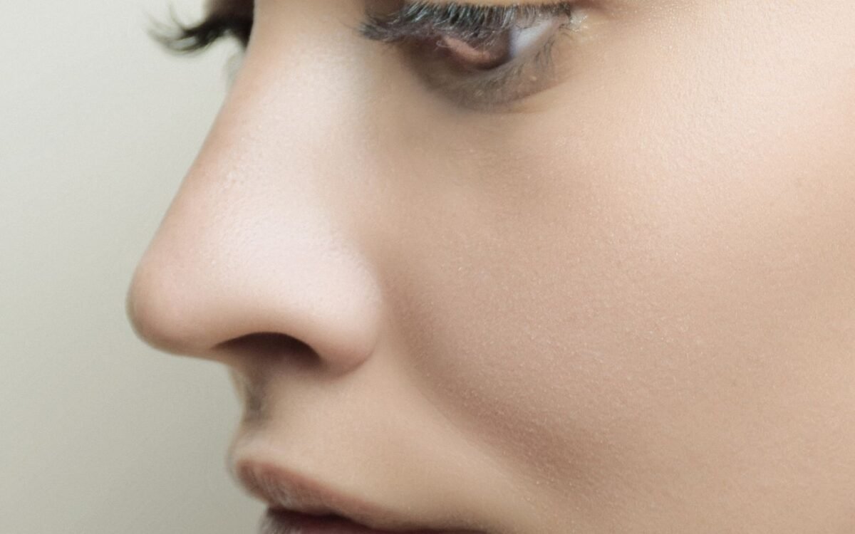 Perfil lateral detalhado do rosto de uma mulher com pele impecável e maquiagem sutil