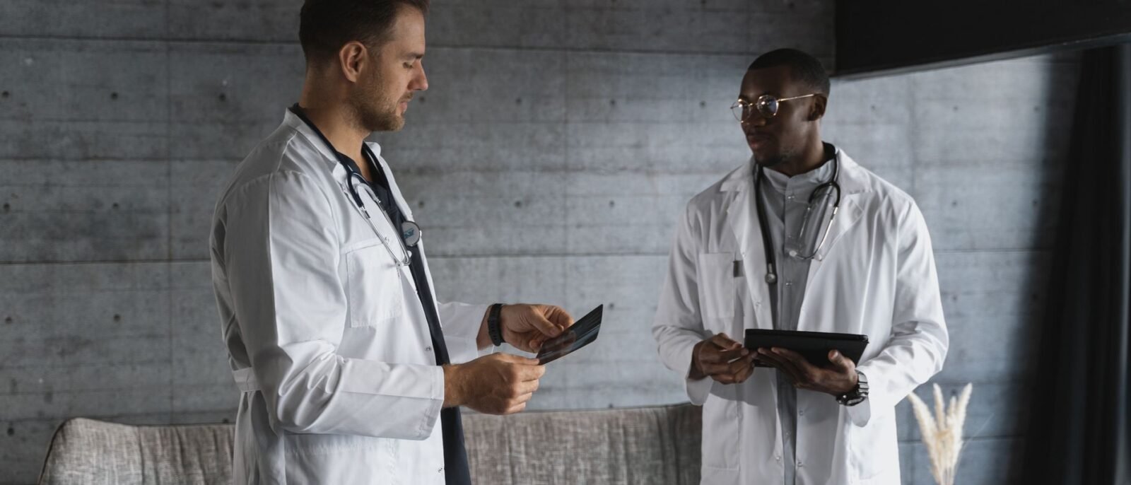 Dois médicos em um consultório médico discutindo uma radiografia, enfatizando trabalho em equipe e expertise em saúde