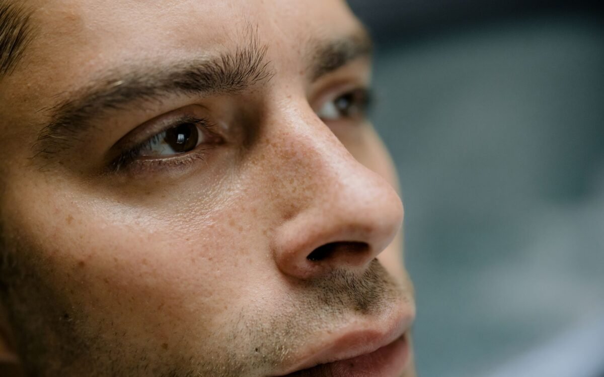 Retrato detalhado em close-up focando nas características faciais e textura de pele de um homem