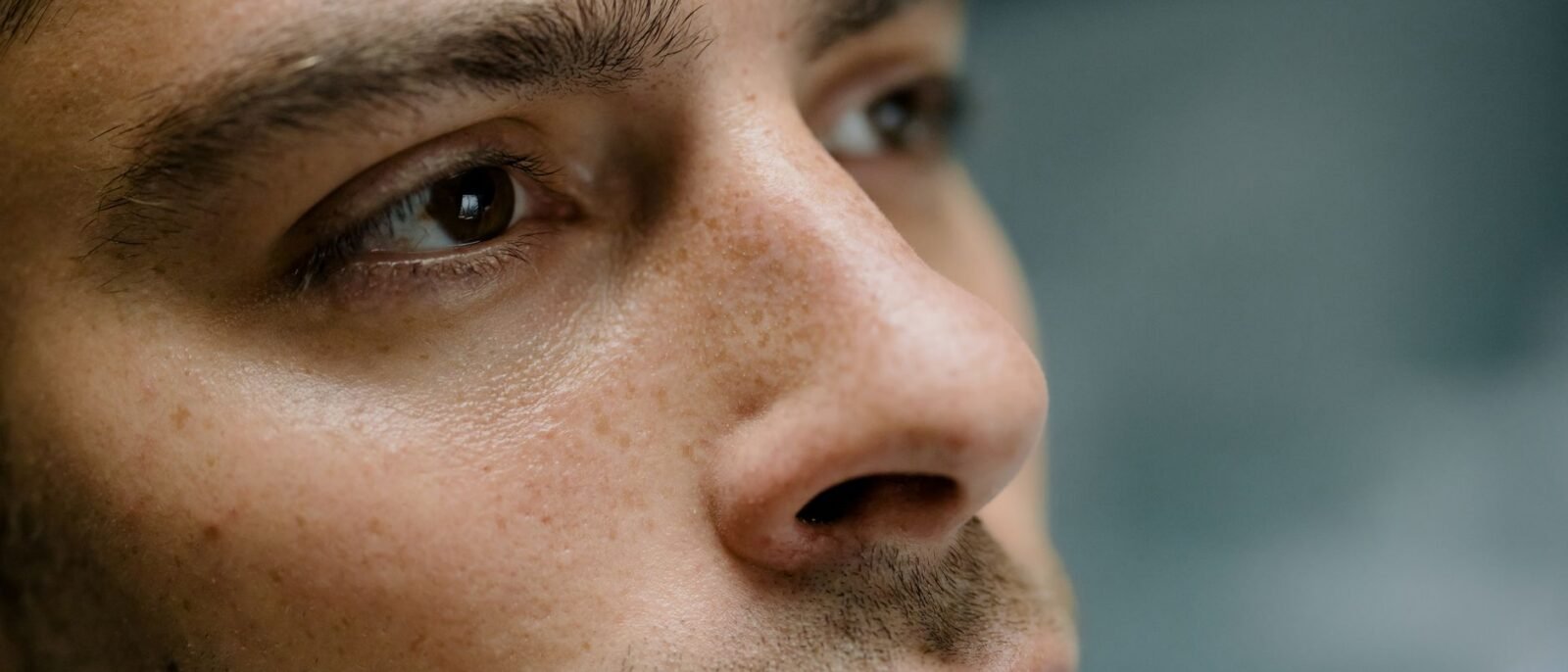 Retrato detalhado em close-up focando nas características faciais e textura de pele de um homem