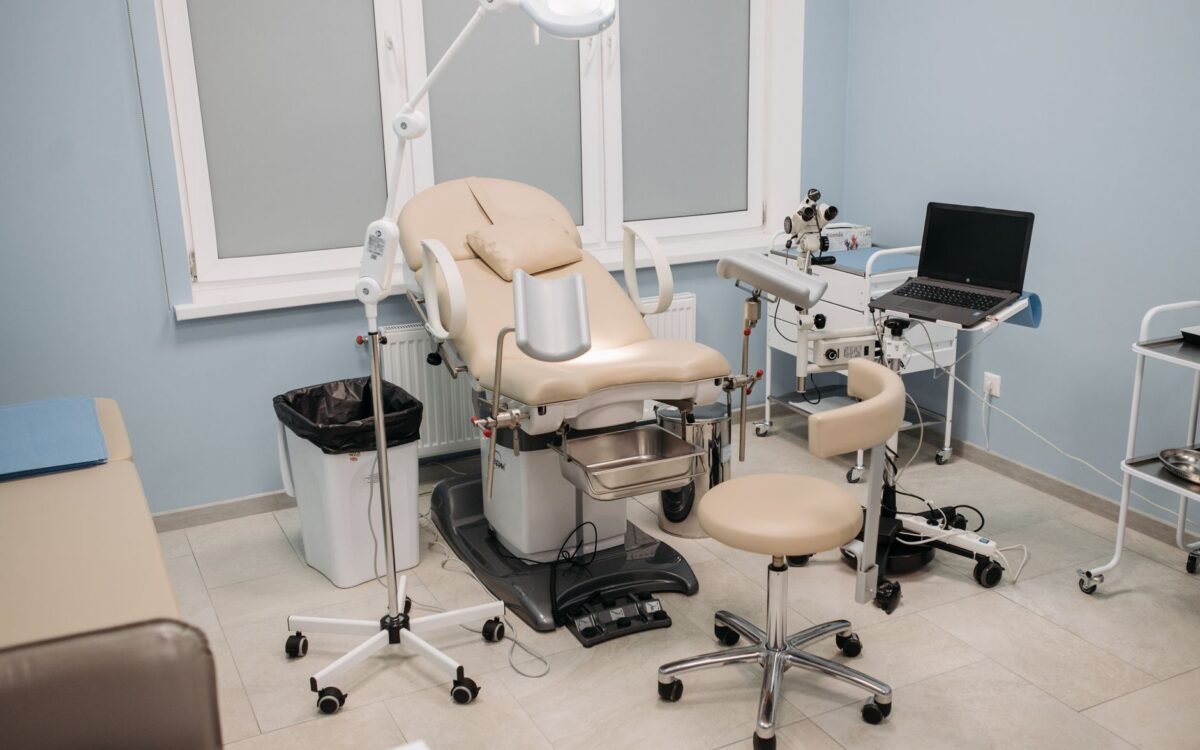 Consultório médico limpo e bem equipado com cadeira de exame e diversos instrumentos médicos