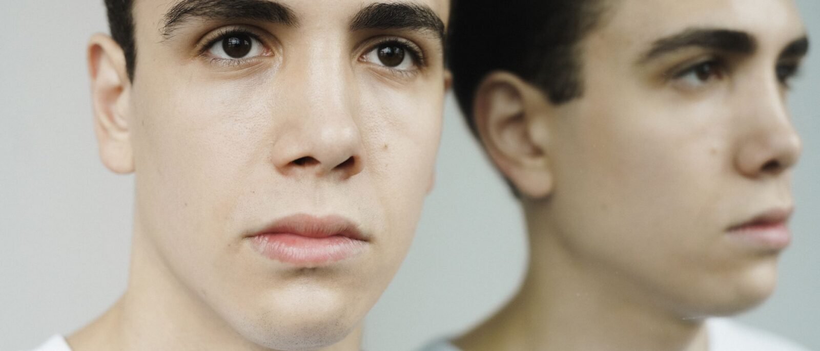 Retrato em close-up de um jovem observando seu reflexo em um espelho