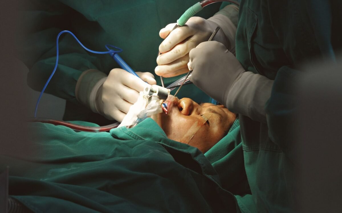 Cirurgiões em ambiente estéril realizando delicada cirurgia facial com instrumentos de precisão